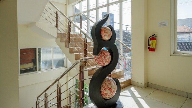 A modern interior with a spiral staircase, large windows, and a fire extinguisher on the wall.