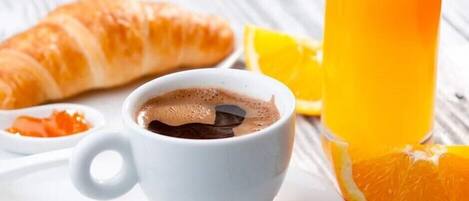 A croissant, a cup of coffee, and a glass of orange juice on a white plate.