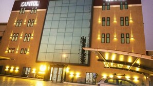A hotel named "Capitol Hotel" with a modern facade, large glass windows, and a well-lit entrance.