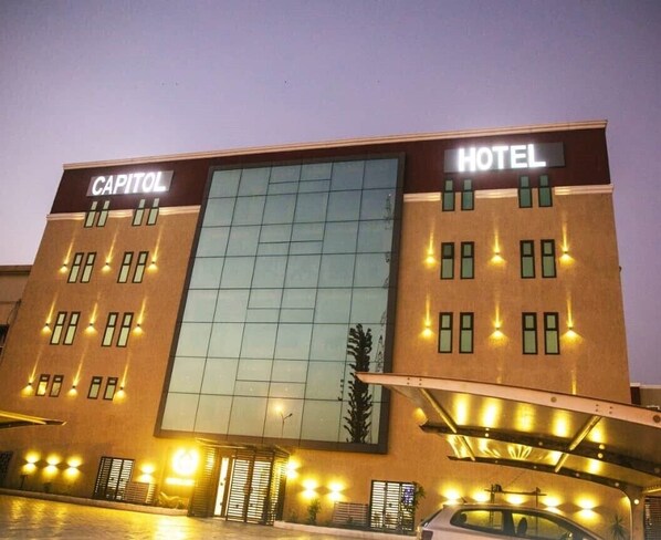 A hotel named "Capitol Hotel" with a modern facade, large glass windows, and a well-lit entrance. - Hotel Capitol Abidjan (Abidjan)