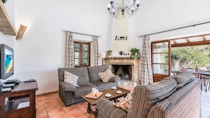 A living room with a fireplace, sofas, a coffee table, and a TV. - TOMAS. Pretty and classical  villa close to Cala San Vicente (Cala San Vicente)