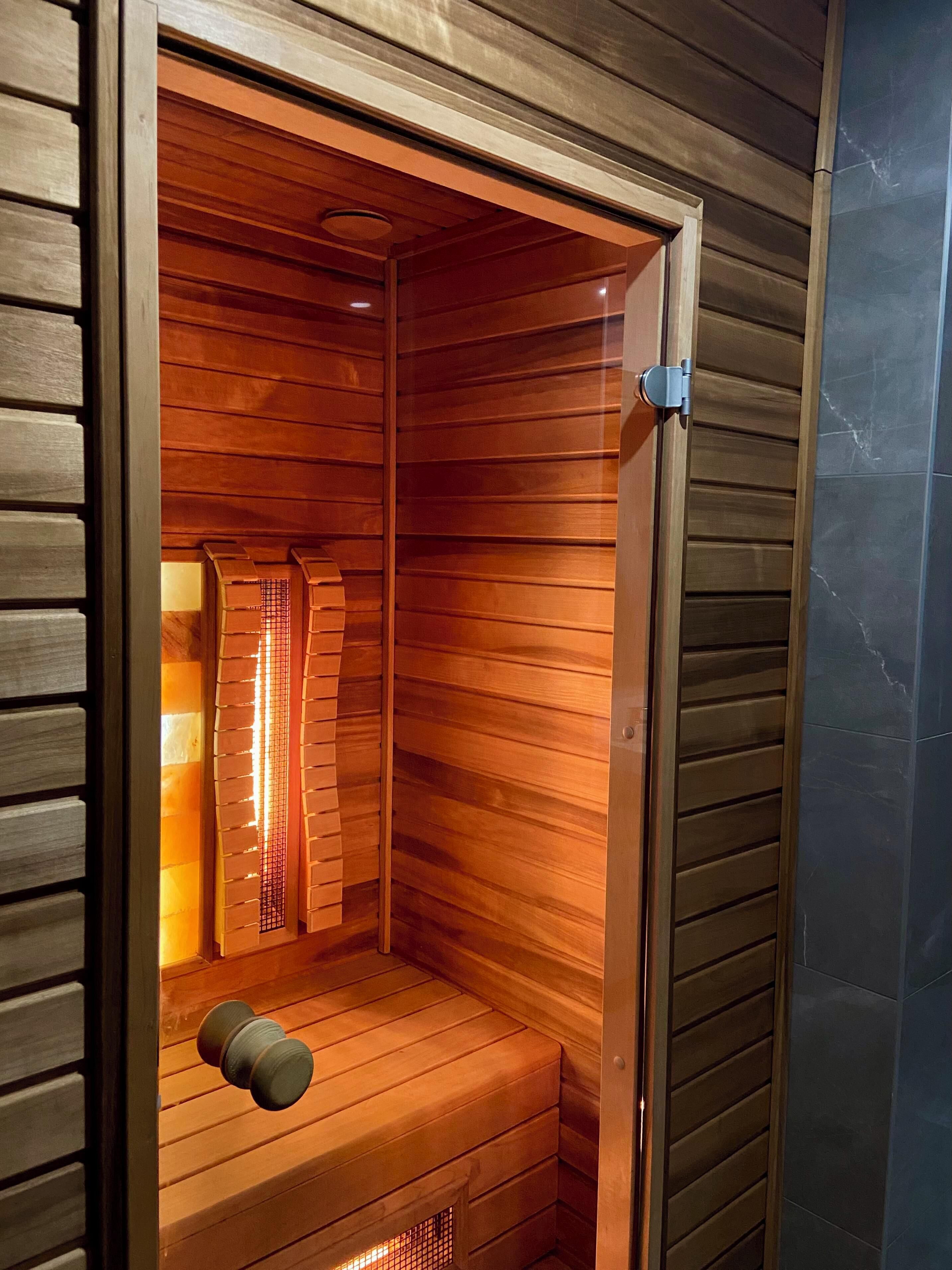 Una sauna de madera con banco y calentador.