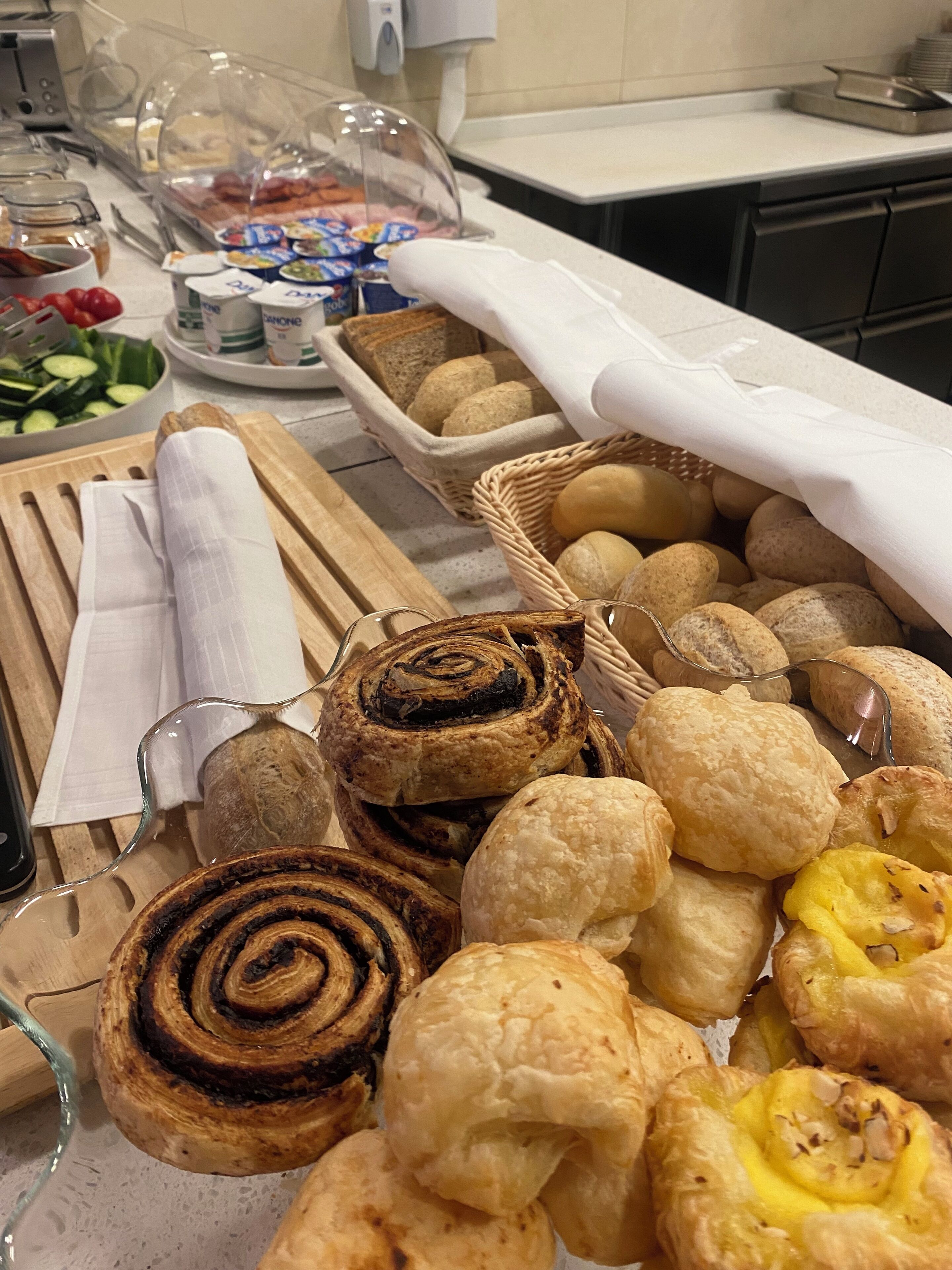 Una taula de bufet amb diferents productes de forneria, com ara carassa, pa i pastissos.