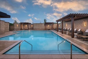 Alberca al aire libre, sombrillas en la alberca y camastros