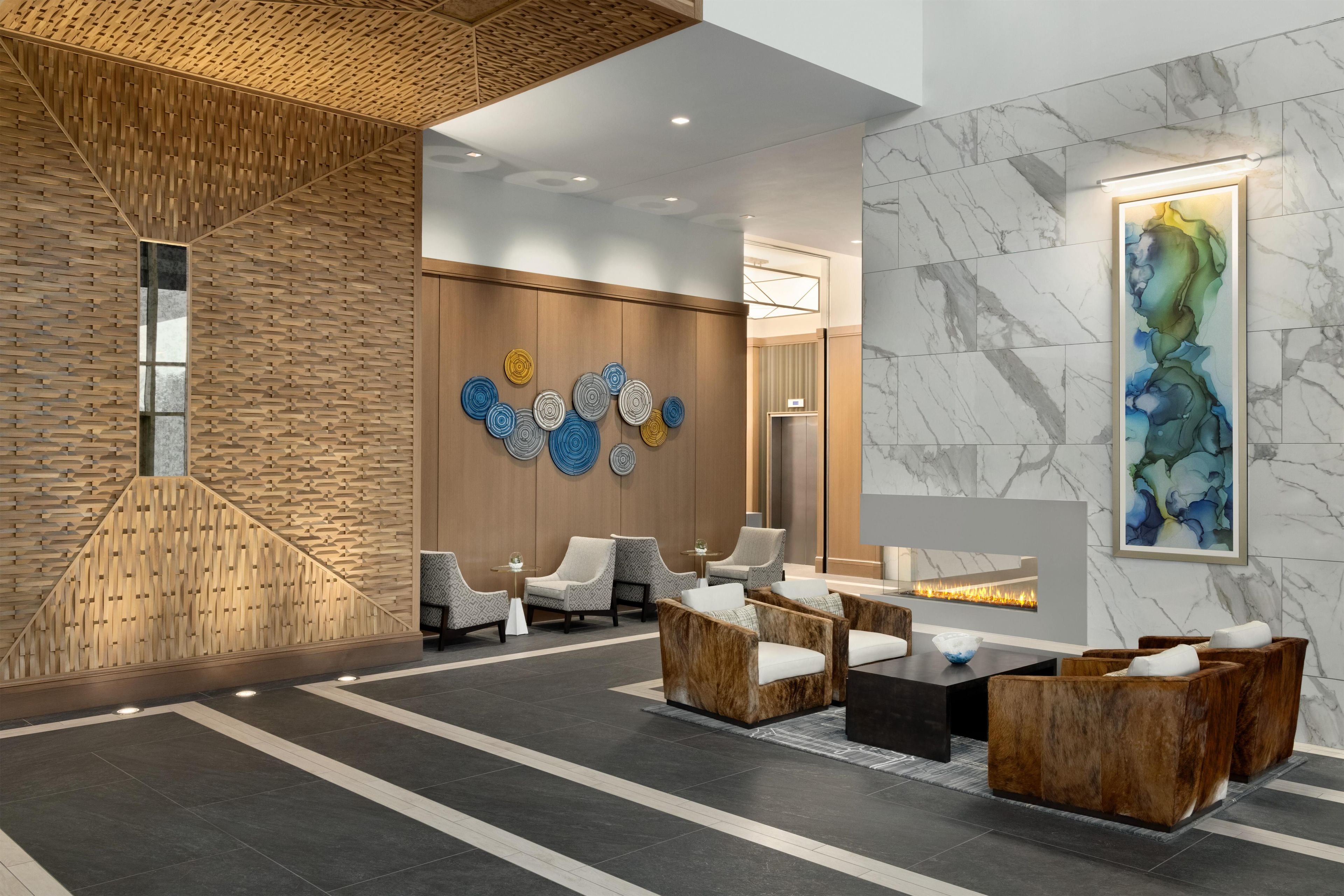Eine moderne Lobby mit Holzwand, Sitzgelegenheit und Kamin.