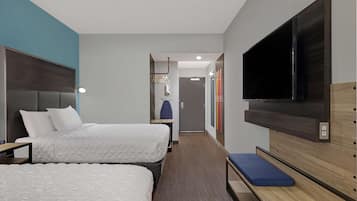 Habitación de hotel con dos camas, televisor, banca y armario.