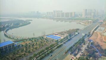 An aerial view of a cityscape with a river, a bridge, and a highway.