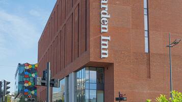 A Hilton Garden Inn with a modern brick facade, large windows, and a clear sky.
