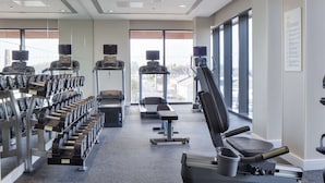 Ett gym med löpband, styrketräningsmaskiner och hantlar.