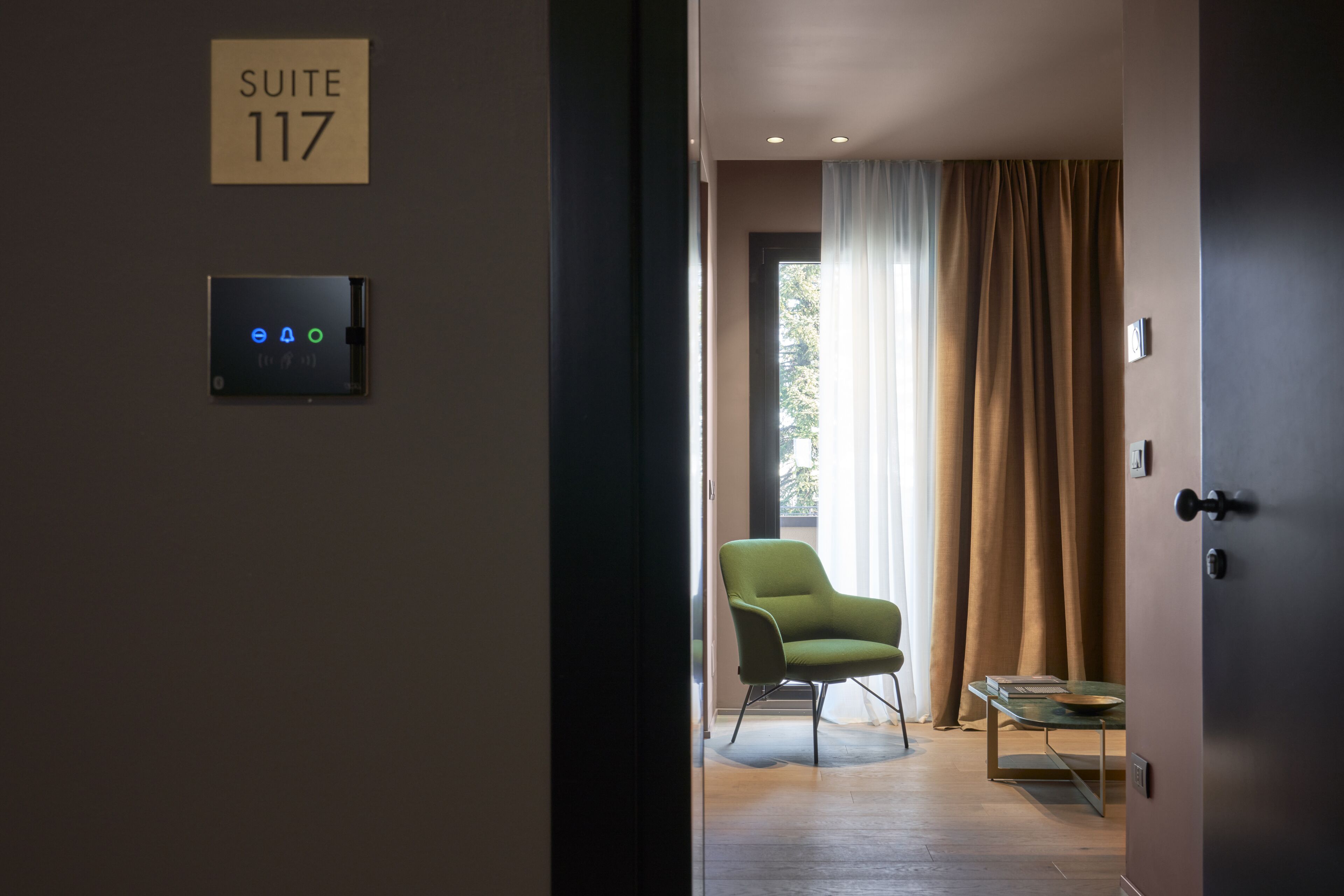 Una habitación de hotel moderna con un cartel que indica 'SUITE 117'.