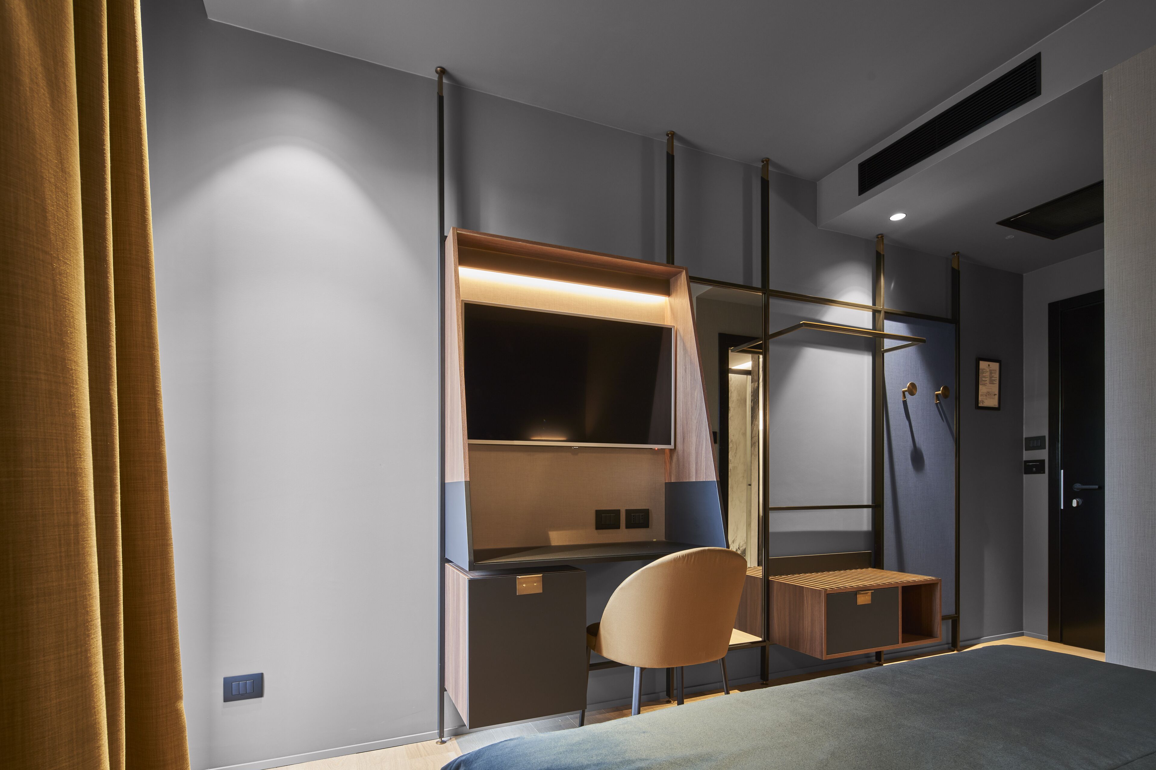 A modern bedroom with a bed, a desk, and a chair.