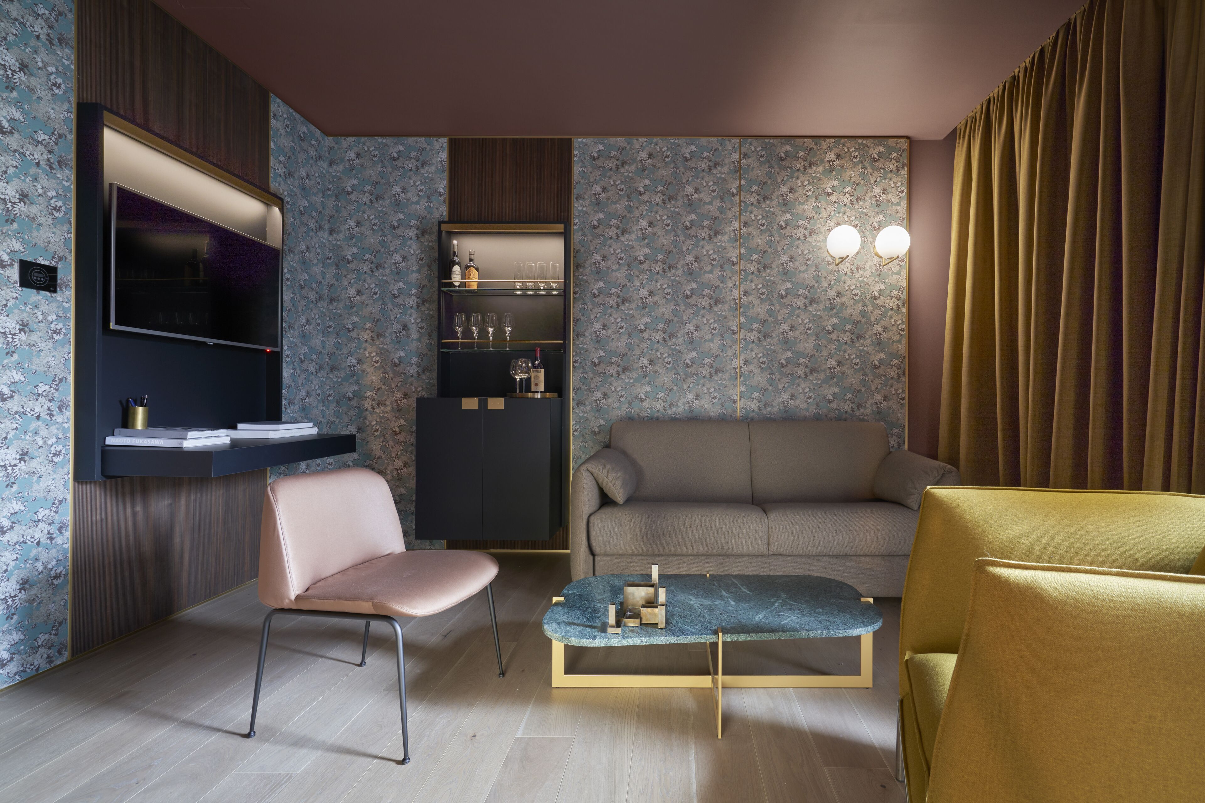 A modern living room with a sofa, a chair, a coffee table, and a TV mounted on the wall.