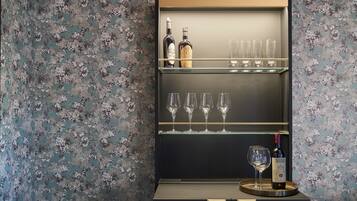 A bar area with two shelves, each holding bottles and glasses.