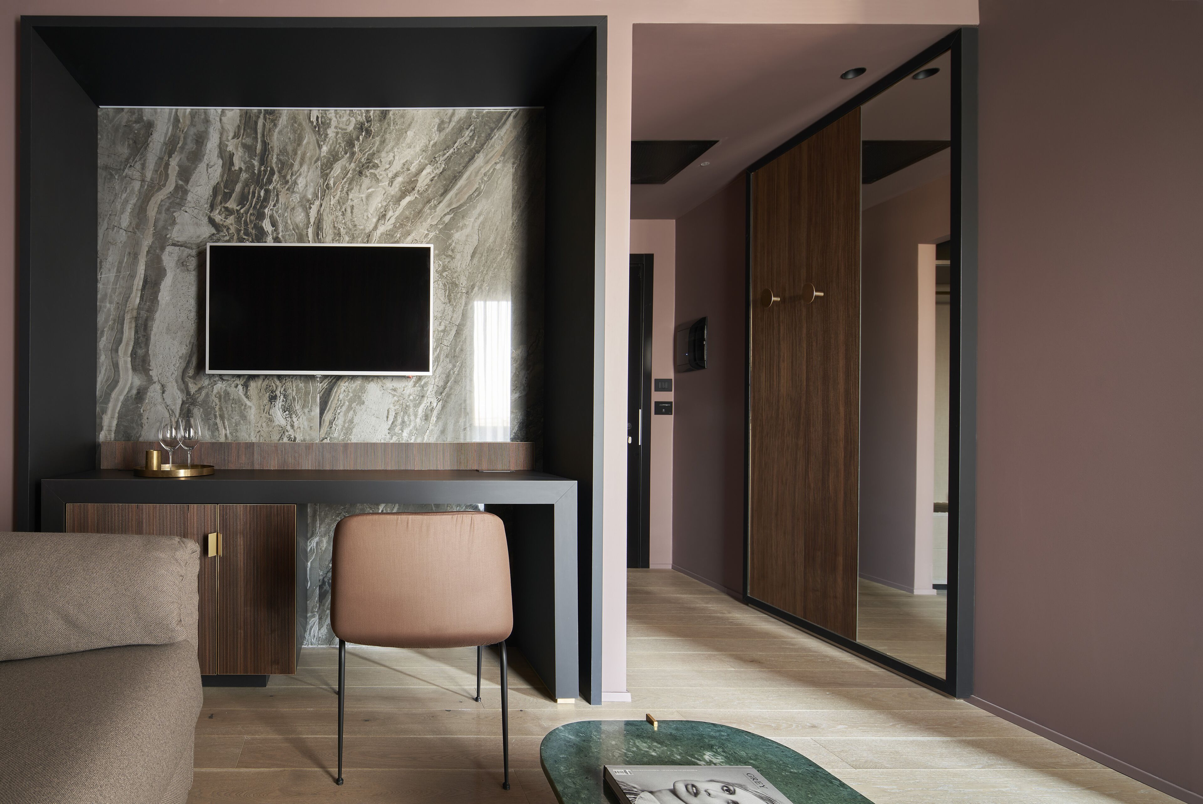 Una sala de estar moderna con chimenea de mármol, televisor de pantalla plana, sofá y mesa de centro.