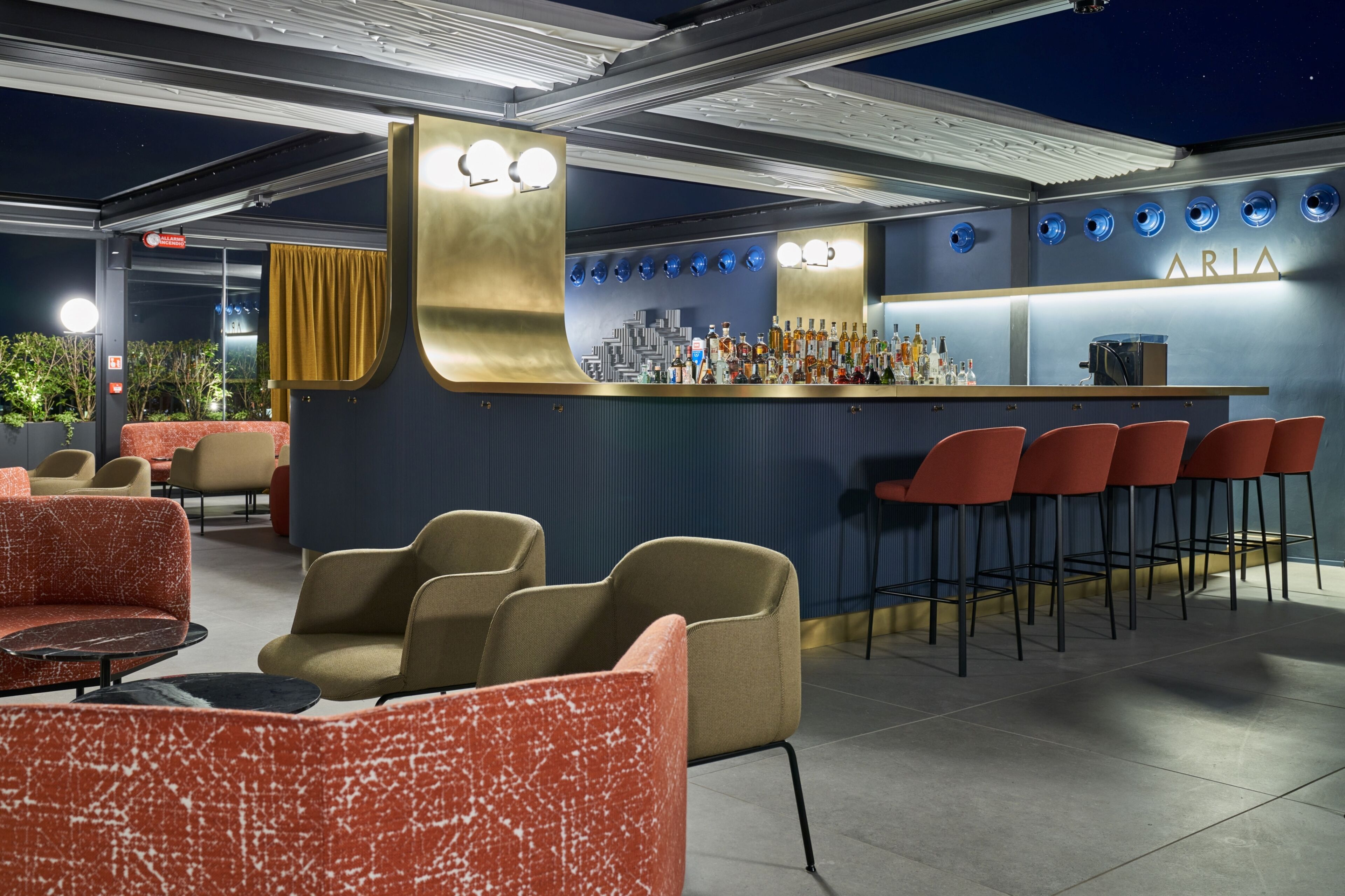 Eine Bar mit Sitzgelegenheiten und einer Theke, an der Flaschen ausgestellt sind.