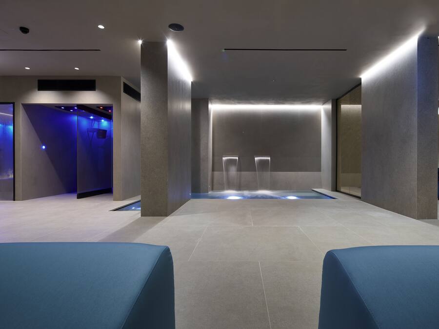 A modern spa area with a central water feature, seating areas, and a minimalist design.