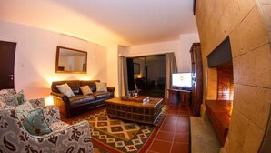 A living room with a sofa, armchairs, a coffee table, and a patterned rug. - Ol Pejeta Mansion (Nanyuki)