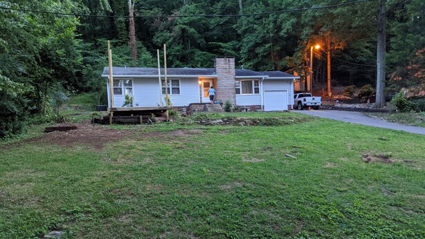 A single-story mobile home with a front porch and a small deck. - Cozy lakeview home (Guntersville)