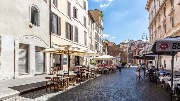 A cobblestone street lined with outdoor cafes, some with umbrellas. - Amazing New Penthouse with Terrace Jewish Ghetto  (Roma)