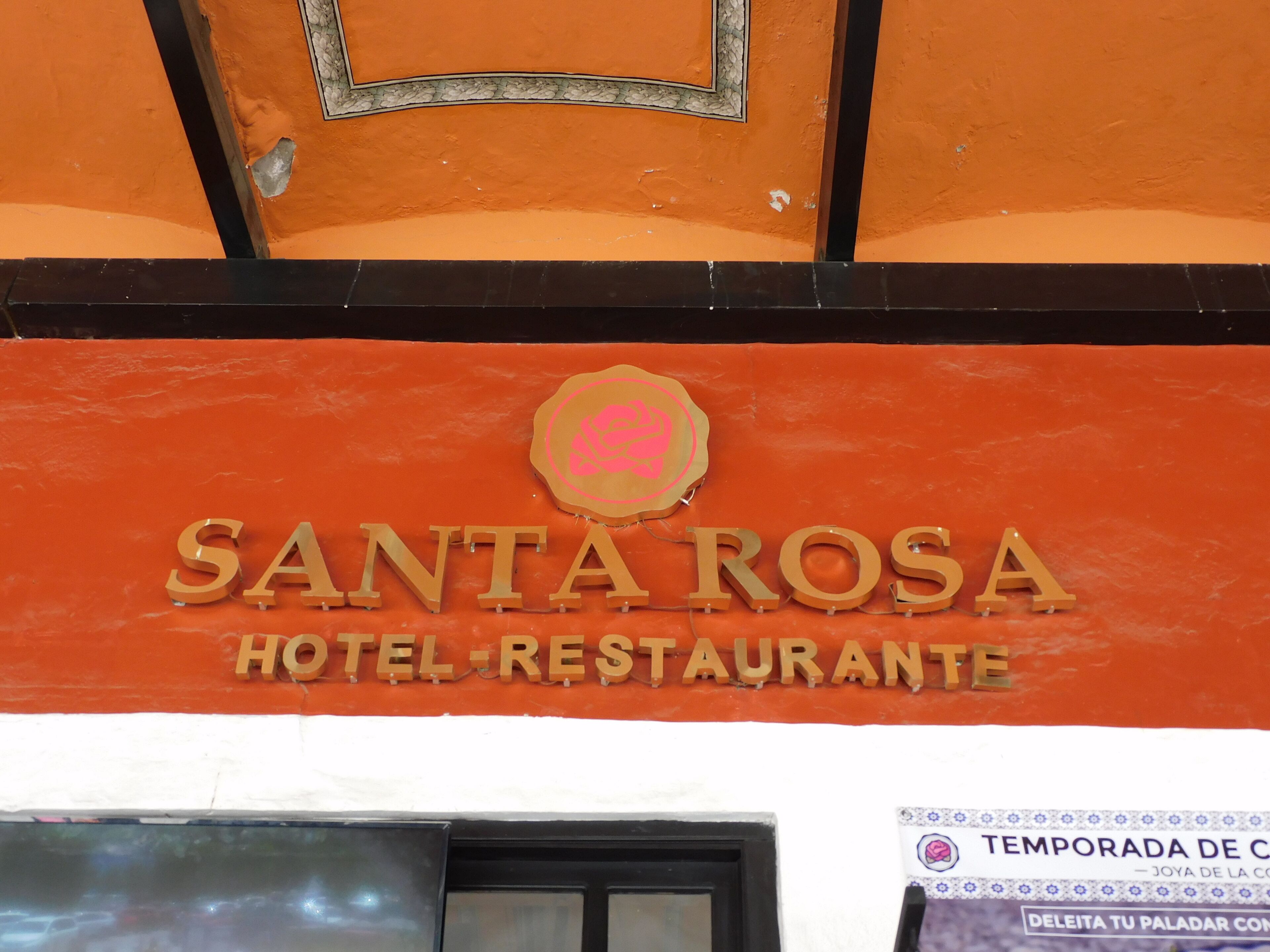Un letrero que dice 'SANTA ROSA HOTEL RESTAURANTE' con un logotipo encima del nombre.