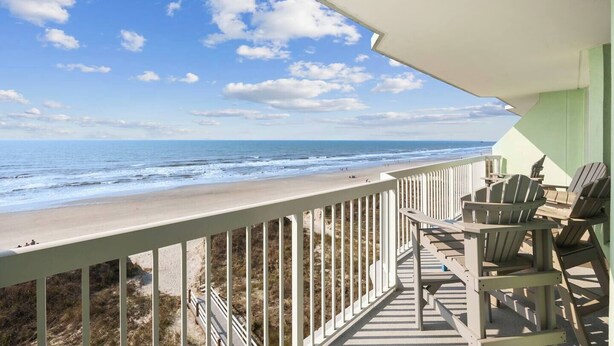 Un balcon avec vue sur la plage et l’océan.