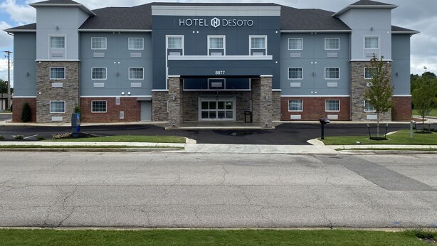 A multi-story hotel with a modern design, featuring a prominent entrance and a large parking lot in front. - Hotel DeSoto (Olive Branch)