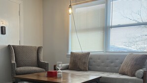 Una sala de estar moderna con un sofá, un sillón y una mesa de centro.