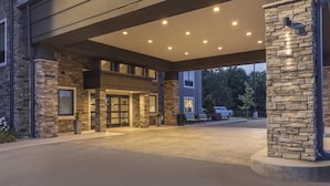 A hotel entrance with a stone facade, a covered walkway, and a car parked outside. - Best Western Plus Lawrenceburg (Lawrenceburg)