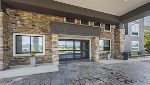A modern building with stone facade, large windows, and a covered entrance area. - Best Western Plus Lawrenceburg (Lawrenceburg)
