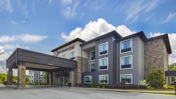 Un hotel moderno con entrada cubierta, varios pisos y fachada de piedra.