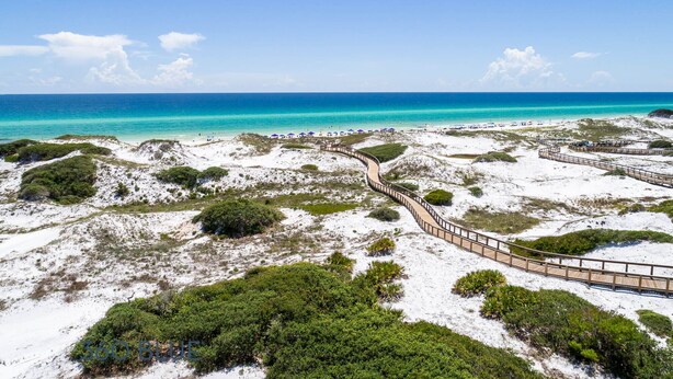 A beach with a wooden boardwalk, sandy dunes, and sparse vegetation. - WaterSound Retreat w/ Pool and Golf Cart (Panama City Beach)