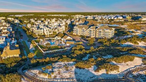 An aerial view of a coastal residential area with a large, multi-story house featuring a swimming pool and a well-maintained lawn. - WaterSound Retreat w/ Pool and Golf Cart (Panama City Beach)