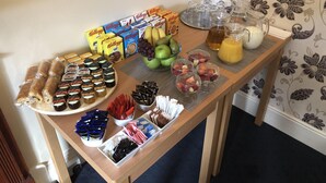 A table with various food items including pastries, chocolates, and fresh fruits. - Harbour Lodge B&B (Paignton)