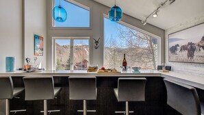 Una cocina moderna con un amplio ventanal, barra y una decoración de cabeza de animal montada.