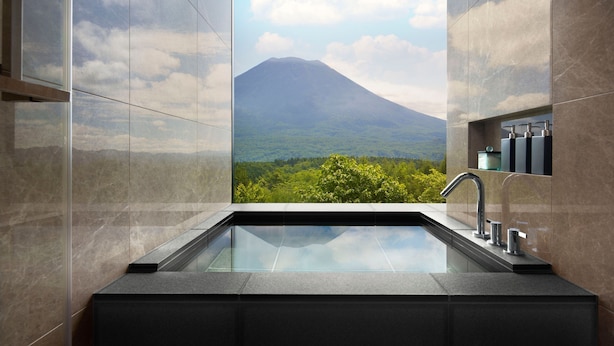 A bathroom with a large window offering a view of a mountain and greenery. - Higashiyama Niseko Village, a Ritz-Carlton Reserve (Niseko)
