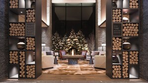 A lobby with a central fire feature, seating area, and a Christmas tree. - Higashiyama Niseko Village, a Ritz-Carlton Reserve (Niseko)