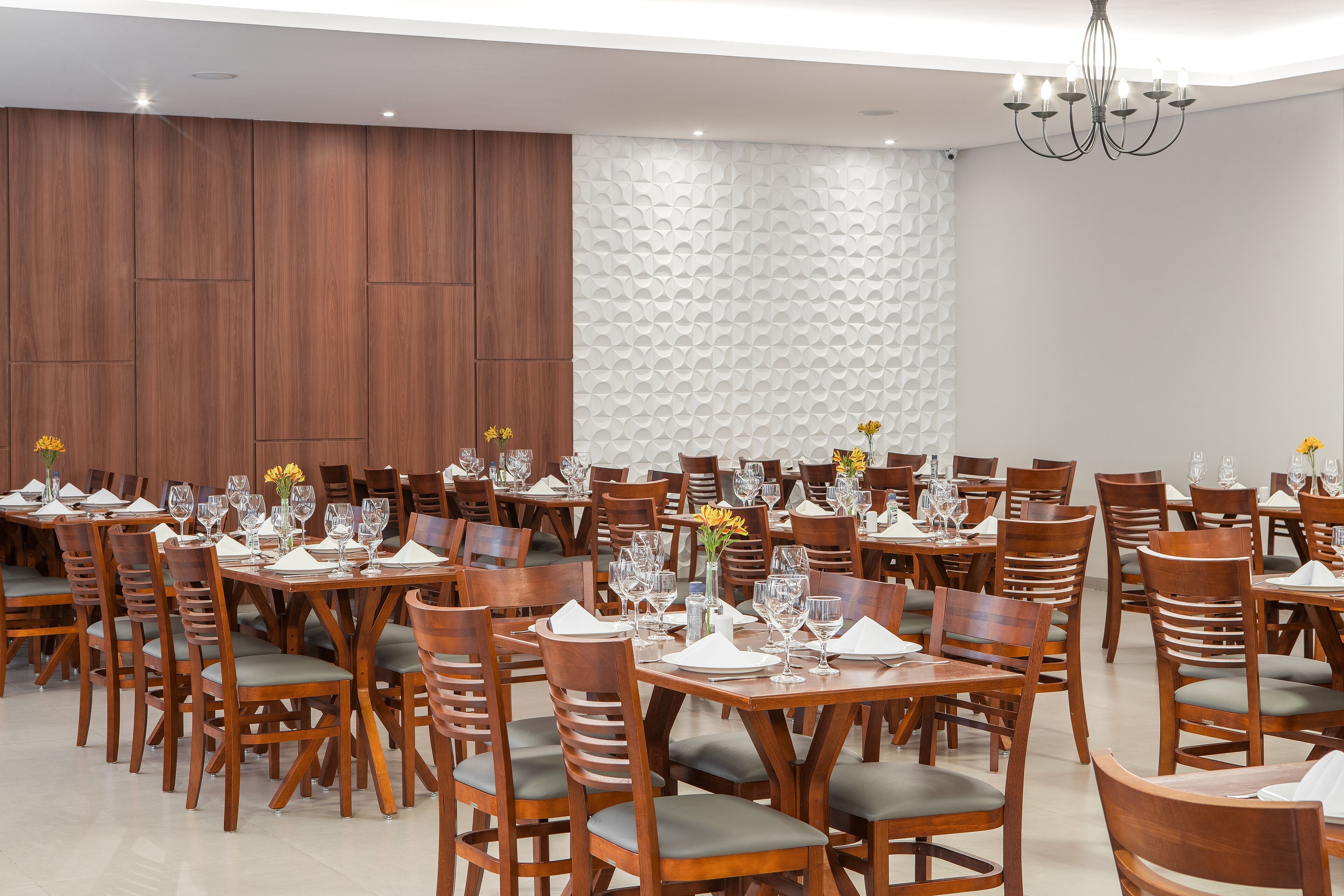 A dining area with multiple tables and chairs, arranged in rows.