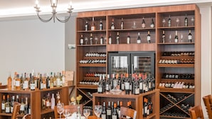 Une cave à vin dotée de plusieurs étagères en bois, remplies de bouteilles de vin et de verres.