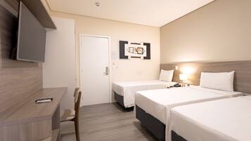 A hotel room with two beds, a desk, a chair, a TV, and a wall-mounted artwork.