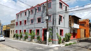 Un edificio de varios pisos con fachada gris y marcos de ventanas rojos.
