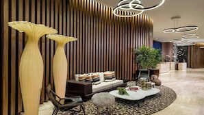A modern interior with a sofa, coffee table, and tall vases. - Luxurious Ocean View 2 Bedroom Escape (Hollywood)