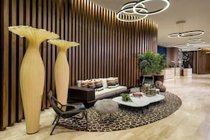 A modern interior with a sofa, coffee table, and tall vases. - Luxurious Ocean View 2 Bedroom Escape (Hollywood)
