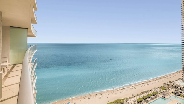 A high-rise building with a balcony overlooking a beach. - Luxurious Ocean View 2 Bedroom Escape (Hollywood)