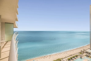Um edifício alto com varanda com vista para a praia.