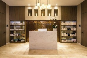 A reception area with a marble counter, wooden shelving with products, and pendant lighting. - Luxurious Ocean View 2 Bedroom Escape (Hollywood)