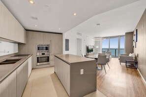 Una cocina moderna con electrodomésticos integrados, una isla central y un comedor con vistas.