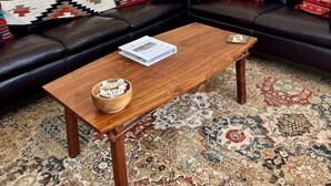 Un salon avec un canapé, une table basse et, au fond, un coin cuisine.