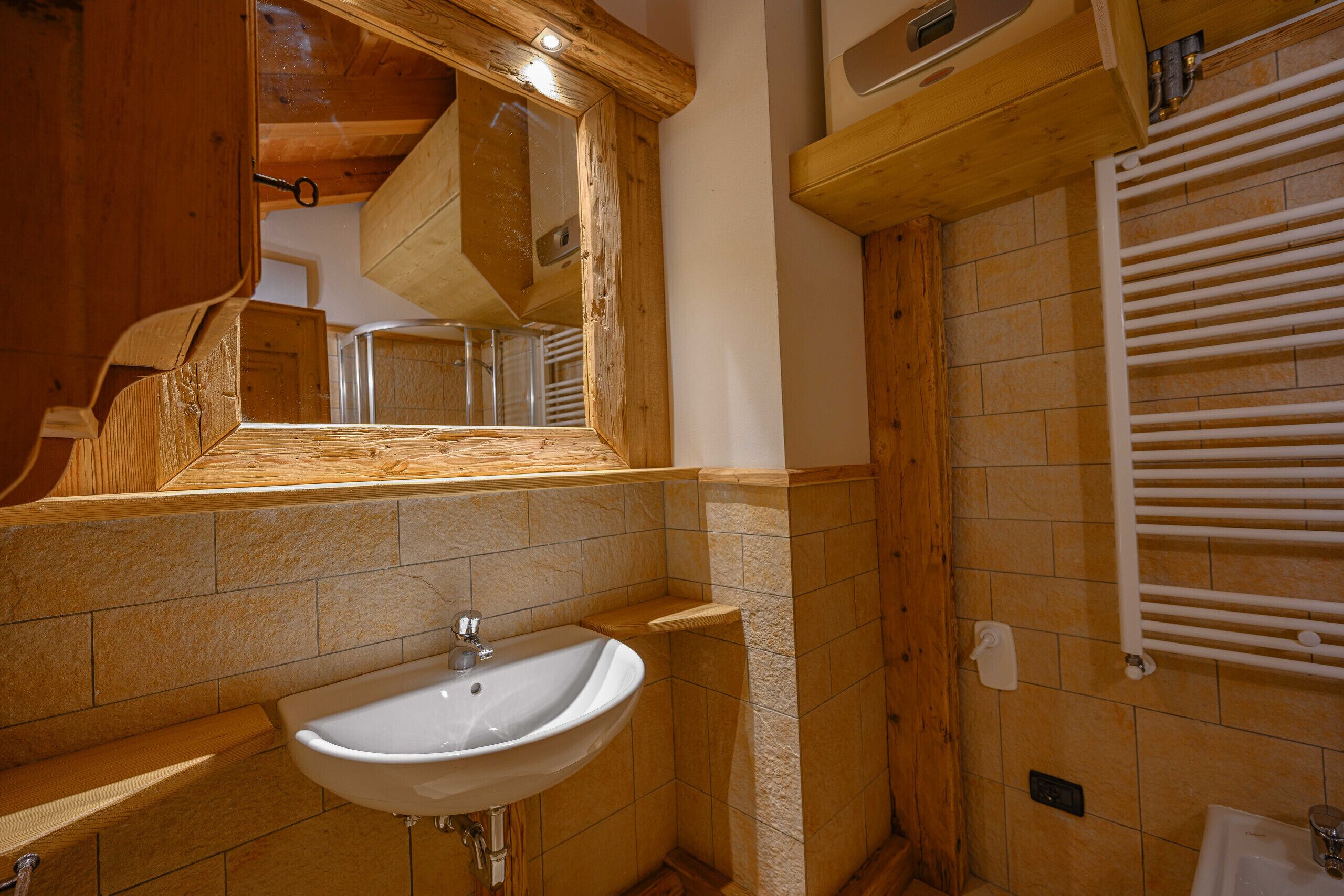 Une salle de bain avec un meuble-lavabo en bois, un évier et un miroir.