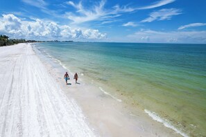 Ein Strand mit klarem türkisblauem Wasser und einem weiten Sandstrand.