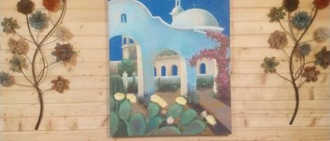 Una pintura de una escena nocturna con una luna, una iglesia y cactus en una pared de madera.